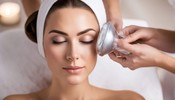 A woman receiving a hyaluronic acid facial treatment at a spa.