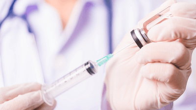 Medical professional filling a syringe.