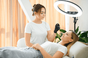 Aesthetician preparing to apply Dermalax filler on a client in a clinical setting, showcasing the professional environment and care involved in the dermal filler process&quot;