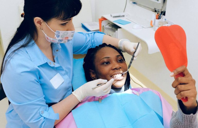 black woman getting a dental exam by a female dentist