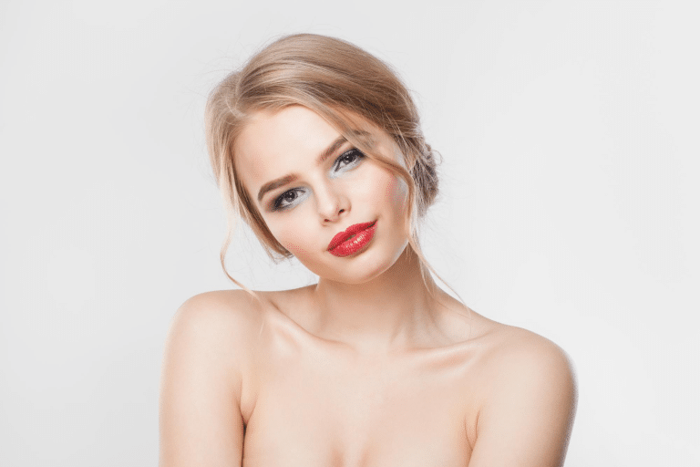 A woman showcasing the potential results of Juvederm lip filler with full, defined lips.