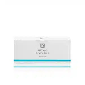 A white rectangular box with blue accents, labeled "NITHYA STIMULATE" followed by "Natural youth" beneath it. The box has a minimalist design with a logo featuring a small, stylized letter "n" at the top center.