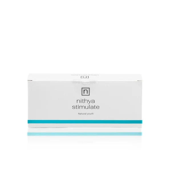 A white rectangular box with blue accents, labeled "NITHYA STIMULATE" followed by "Natural youth" beneath it. The box has a minimalist design with a logo featuring a small, stylized letter "n" at the top center.