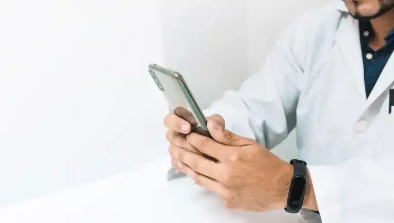 doctor checking social media updates on his phone