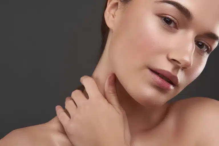 Woman with hand placed gently on her neck